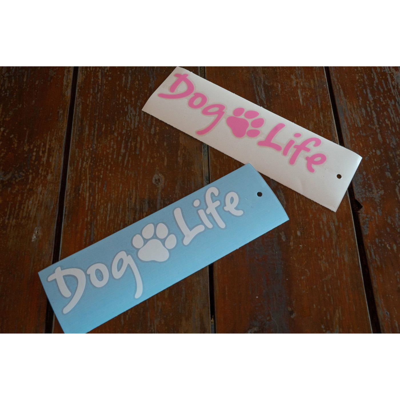 Dog Life decals in white and pink on a wooden table